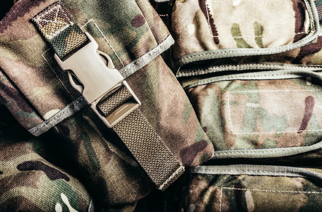 Close-up photo of multi camouflaged soldier vest pouches with lock catch. Waterfowl hunting bag.